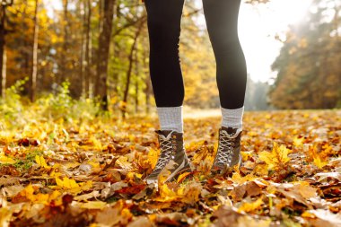 Canlı bir orman ortamındaki renkli yapraklarla çevrili sağlam çizmelerle sonbahar patikalarını keşfediyorum. Ormanda güzel bir sonbahar gününün tadını çıkarıyorum..