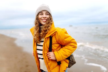 Seyahat eden kadın kıyıda yürüyor, temiz deniz havasının tadını çıkarıyor. Sakinlik ve sükunet. Seyahat, turizm konsepti.