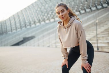 Genç bir kadın, güneşli bir öğleden sonra modern bir açık hava ortamında yoga yapıyor. İnsanlar, spor, spor ve esneklik kavramı