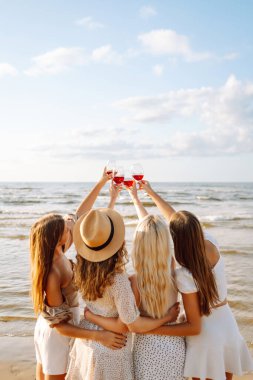 Yaz kıyafetleri giymiş dört kadın arkadaştan oluşan bir grup gün batımında sahilde duruyor. Kadehlerini kaldırarak okyanus kıyısındaki dostluklarını kutluyorlar. Kumsalda kızlar partisi.. 