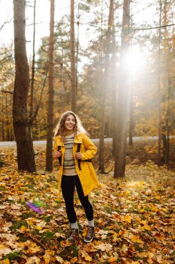 Mutlu kadın ormanda eğleniyor ve sonbahar havasının tadını çıkarıyor. Sakinlik ve sükunet. Seyahat, turizm konsepti.