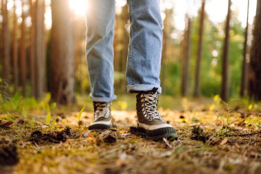 Yürüyüşçünün botları ormanda düşen portakal yapraklarından bir battaniyeye basıyor. Seyahat, yürüyüş..