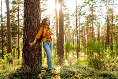Genç bir kadın ormanda yürüyüşe çıktı. Kendini özgür ve enerjik hissediyordu. Sonbahar manzarası.