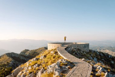 Anıları yakalamak. Genç bir kadın telefon için Negosh Anıt Mezarı 'na gitti. Turizm, doğa, blog konsepti.