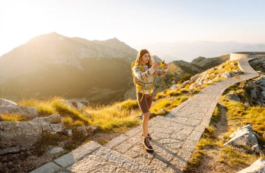 Anıları yakalamak. Genç bir kadın telefon için Negosh Anıt Mezarı 'na gitti. Turizm, doğa, blog konsepti.
