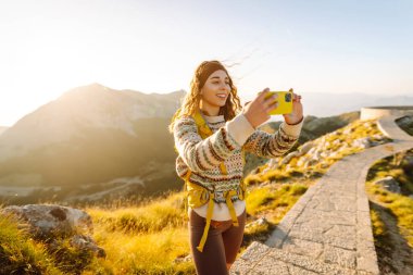 Anıları yakalamak. Genç bir kadın telefon için Negosh Anıt Mezarı 'na gitti. Turizm, doğa, blog konsepti.