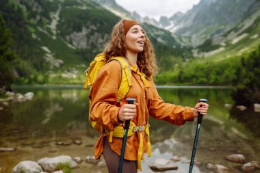 Sırt çantalı aktif kadın turist görkemli dağların güzel manzarasının tadını çıkarıyor. Yürüyüş. Seyahat, macera.