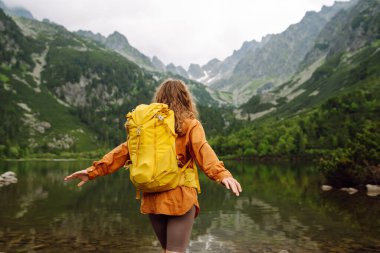 Sırt çantalı aktif kadın turist görkemli dağların güzel manzarasının tadını çıkarıyor. Yürüyüş. Seyahat, macera.