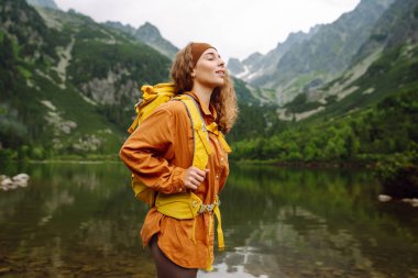 Sırt çantalı aktif kadın turist görkemli dağların güzel manzarasının tadını çıkarıyor. Yürüyüş. Seyahat, macera.