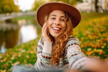 Mutlu Turist havanın tadını çıkarıyor, sarı yapraklı bir fotoğraf çekiyor. Seyahat blogu. Selfie zamanı..