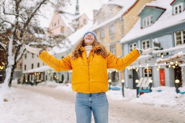 Kış sokağında karla oynayan güzel bir kadın. Yürüyüş kavramı, hafta sonları. Kış tatili