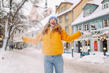 Kış sokağında karla oynayan güzel bir kadın. Yürüyüş kavramı, hafta sonları. Kış tatili