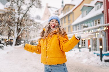 Kış sokağında karla oynayan güzel bir kadın. Yürüyüş kavramı, hafta sonları. Kış tatili