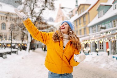 Kış sokağında karla oynayan güzel bir kadın. Yürüyüş kavramı, hafta sonları. Kış tatili