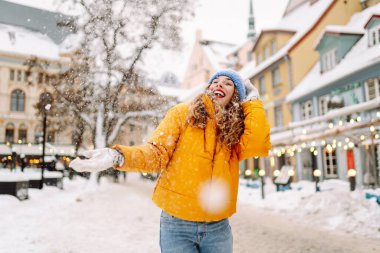 Kış sokağında karla oynayan güzel bir kadın. Yürüyüş kavramı, hafta sonları. Kış tatili