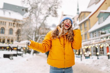 Kış sokağında karla oynayan güzel bir kadın. Yürüyüş kavramı, hafta sonları. Kış tatili