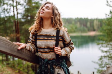 Genç turist kadın dağ gölü manzarasının tadını çıkarıyor. Doğayla baş başa. Etkin yaşam biçimi.