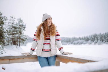 Kışlık giysiler içinde kışın tadını çıkaran neşeli bir kadın. Kış tatili.