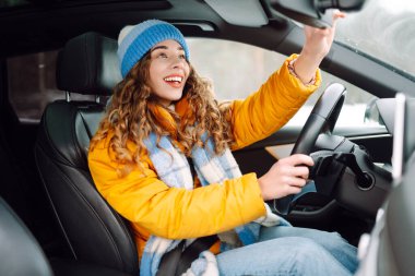 Kışın araba süren mutlu bir kadın. Ulaşım konsepti, yaşam tarzı.
