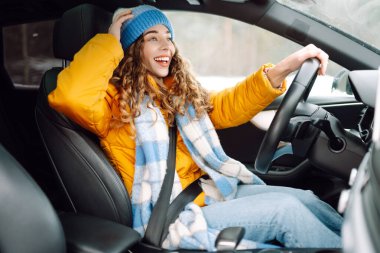 Kışın araba süren mutlu bir kadın. Ulaşım konsepti, yaşam tarzı.