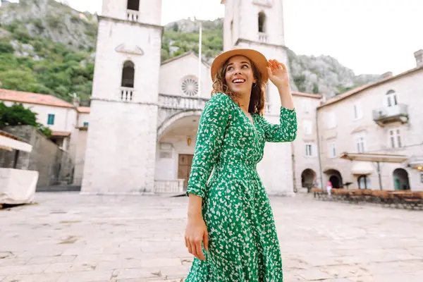 Şehrin sokaklarında yürüyen güzel elbiseli mutlu bir bayan turist. Moda tarzı. Tatil ve seyahat kavramı. 