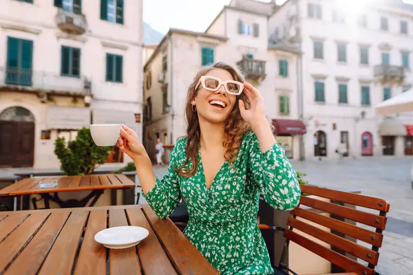 Mutlu kadın turist yaz gezisinde eski kasabada kahve içer. Dinlenme zamanı..