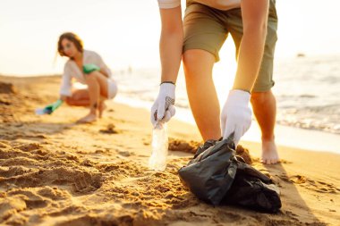 Okyanus kıyısındaki çöpleri temizleyin. Plastikten plajı gönüllü temizleme. Ekolojinin korunumu kavramı.