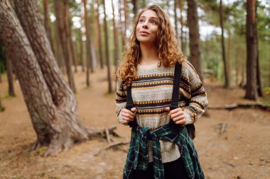 Turist kadın doğal ormanda tek başına yürüyüş yapıyor. Aktif yaşam tarzı. Ormandaki insanlar. Doğa, seyahat, dinlenme konsepti.