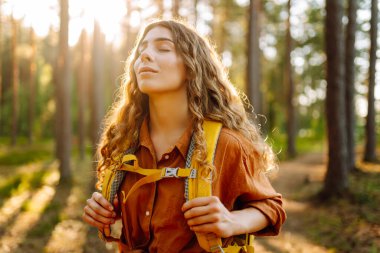 Stylish woman enjoying autumn weather in the park. Autumn mood. Hiking. clipart