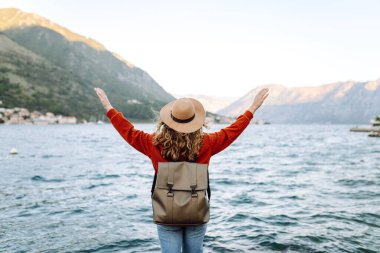 Manzaralı gölü ve dağ manzaralı gezgin kadının arka manzarası. Açık hava macerası, özgürlük, mutluluk kavramı.