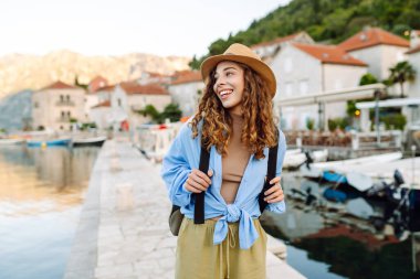 Avrupa 'da tatiller. Sur boyunca yürür. Güzel bayan turist şehir manzarasının tadını çıkarıyor..