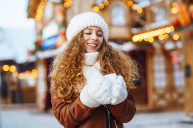 Mutlu kadın güler ve kışın Noel pazarına kar atar. O, güzel kış havasının tadını çıkarıyor. Kış tatili.