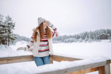 Şapkalı ve eşarplı mutlu kadın kış gününün tadını çıkarıyor. Doğa, tatiller, dinlenme, seyahat konsepti.