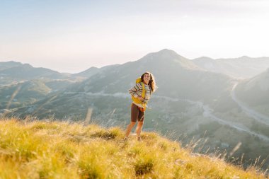 Dağlarda yürüyüş yapan bir kadın mola veriyor. Güzel dağların manzarası. Macera aktif.