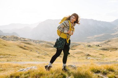 Sırt çantalı gezgin kadın dağda yürüyor. Macera aktif. Manzaranın tadını çıkar.