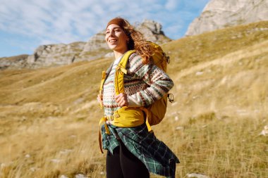 Sırt çantalı gezgin kadın dağda yürüyor. Macera aktif. Manzaranın tadını çıkar.