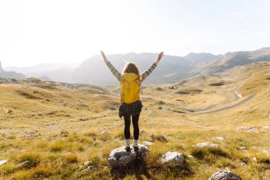 Sırt çantalı gezgin kadın dağda yürüyor. Macera aktif. Manzaranın tadını çıkar.