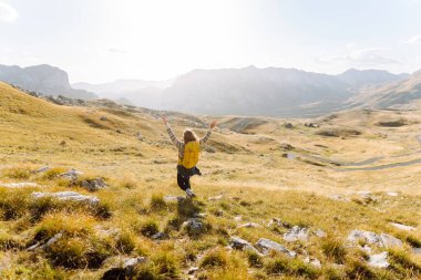 Sırt çantalı gezgin kadın dağda yürüyor. Macera aktif. Manzaranın tadını çıkar.