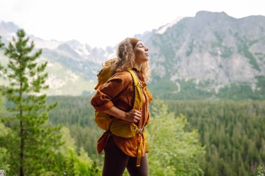 Genç bir gezgin dağ patikaları boyunca seyahat eder. Yürüyüş. Macera, seyahat konsepti.