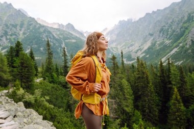 Genç bir gezgin dağ patikaları boyunca seyahat eder. Yürüyüş. Macera, seyahat konsepti.