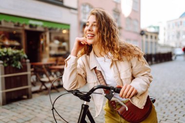 Şehir caddesinde bisiklet süren genç bir kadın. Aktif yaşam tarzı. Eko taşımacılığı.