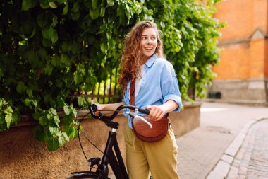 Şehir caddesinde bisiklet süren genç bir kadın. Aktif yaşam tarzı. Eko taşımacılığı.