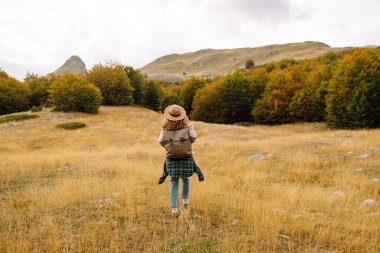 Kayalık bir bölgede bir kadın patikada yürüyor. Yol dar ve kayalık. Seyahat, macera. Etkin bir yaşam biçimi kavramı.