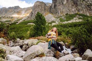 Gezgin kadın sırt çantasıyla kayalık bir yolda yürüyor. Seyahat, macera. Etkin bir yaşam biçimi kavramı.