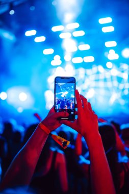 Telefon kayıtlarıyla birlikte canlı müzik festivali. Akıllı telefonla fotoğraf çeken insanlar..