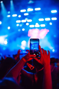 Telefon kayıtlarıyla birlikte canlı müzik festivali. Akıllı telefonla fotoğraf çeken insanlar..