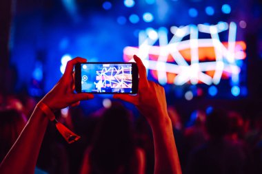 Telefon kayıtlarıyla birlikte canlı müzik festivali. Akıllı telefonla fotoğraf çeken insanlar..