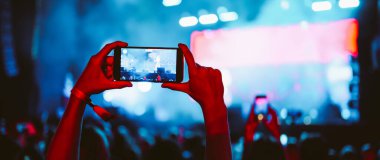 Telefon kayıtlarıyla birlikte canlı müzik festivali. Akıllı telefonla fotoğraf çeken insanlar..