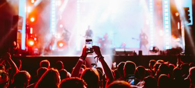 Telefon kayıtlarıyla birlikte canlı müzik festivali. Akıllı telefonla fotoğraf çeken insanlar..