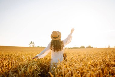 altın buğday tarlasında genç güzel kadın. yaz kavramı, özgürlük, sıcaklık, hasat, rekreasyon, tarım.